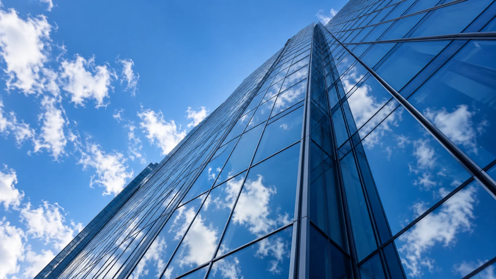 Glass architecture reflecting a clear blue sky