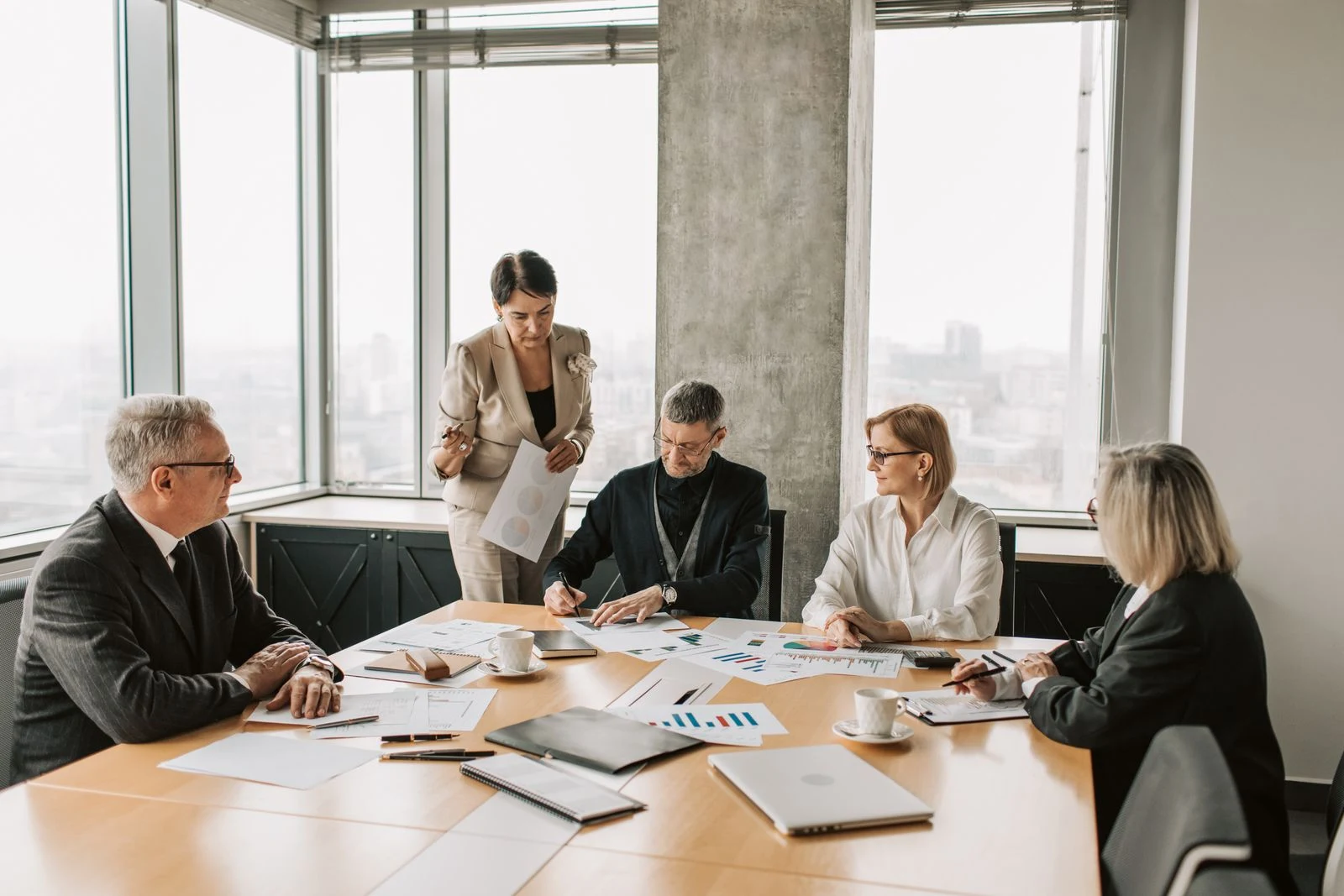 Business colleagues reviewing charts and documents around a meeting table